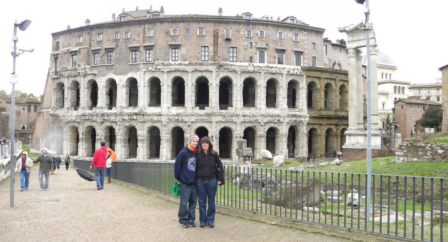 Wendy with a young man standing in front of the Colosseum in Rome, Italy.