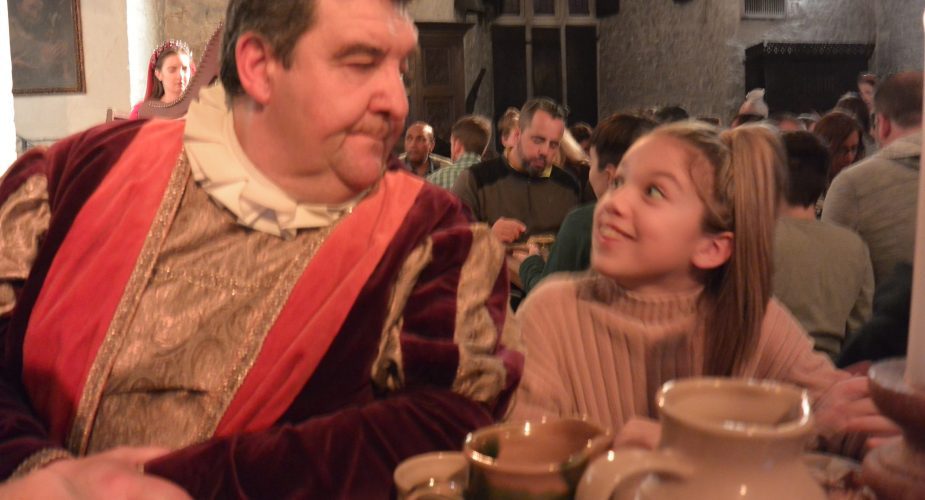 A young girl smiling and looking at a gentleman dressed in period clothing in Ireland.