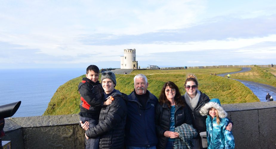 Wendy and her family posing in front of a castle in Ireland.