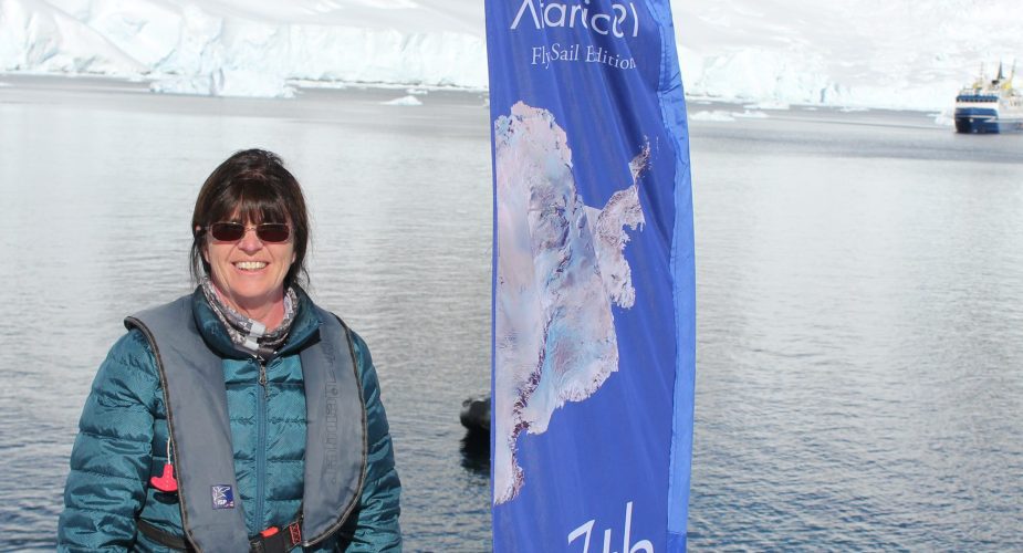 Wendy posing next to a flag in Antarctica